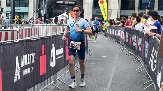 Ira May läuft den Jungfernstieg beim Ironman in Hamburg entlang. An der Laufstrecke schauen viele Menschen zu.
