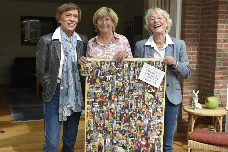 Irmhild Reimers, Claudine Wonner-Panten und Ursel Imhof (von links) mit dem selbst entworfenen Geschenkpapier der Soroptimisten Buxtehude.  Foto Felsch