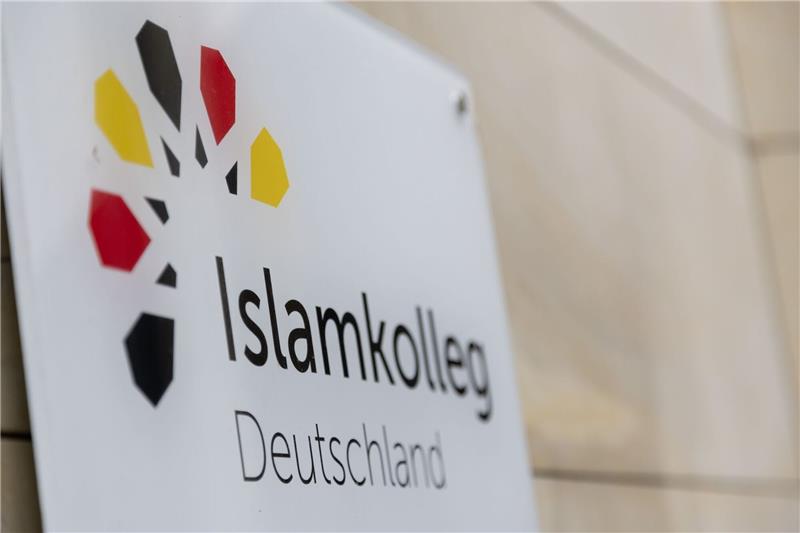 Absolventen des Islamkolleg Deutschland bekommen Zertifikate «Islamkolleg Deutschland» steht auf einem Schild an einem Gebäude.