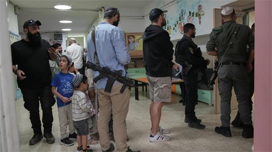 Israel-Wahl: Bewaffnete Siedler warten am Wahllokal