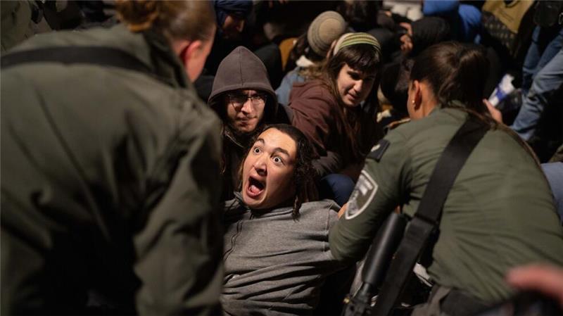 Israelische Beamte entfernen rechte Aktivisten, die während einer Demonstration in Jerusalem gegen die Waffenruhe zwischen Israel und der Hamas eine Straße blockieren.