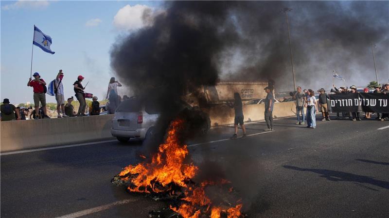 Israelische Demonstranten blockieren eine Straße bei einem Protest.
