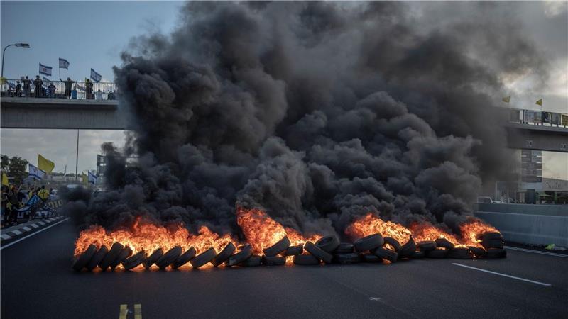 Bilder des Tages Israelische Demonstranten blockieren mit brennenden Reifen die Hauptverkehrsstraße in Zentralisrael.