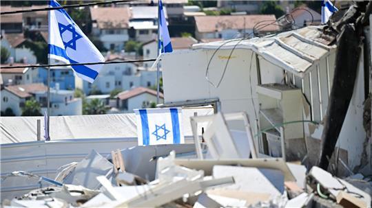 Israelische Fahnen an Ort eines iranischen Raketenangriffs in Beit Schemesch. 