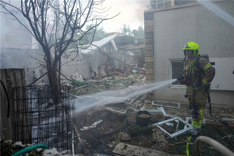 Großangriff der Hamas auf Israel - Mehrere hundert Tote Israelische Feuerwehrleute löschen ein Feuer, nachdem eine aus dem Gazastreifen abgefeuerte Rakete ein Haus im Süden Israels getroffen hat.