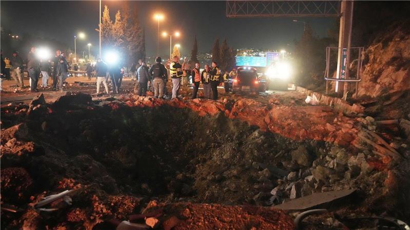 Israelische Sicherheitskräfte inspizieren eine beschädigte Straße, nachdem eine aus dem Iran abgefeuerte Rakete in Jerusalem eingeschlagen ist.