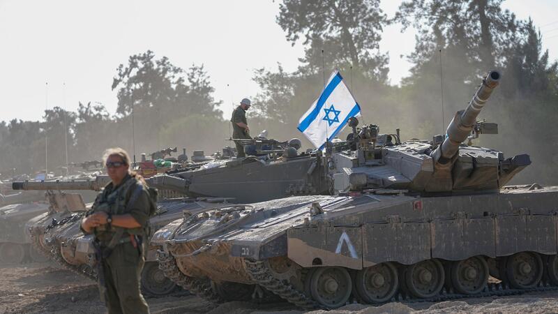 Israelische Soldaten arbeiten an einem Panzer in der Nähe der Grenze zum Gazastreifen. Bislang ist offen, wann das israelische Militär eine Bodenoffensive im Gazastreifen beginnt.