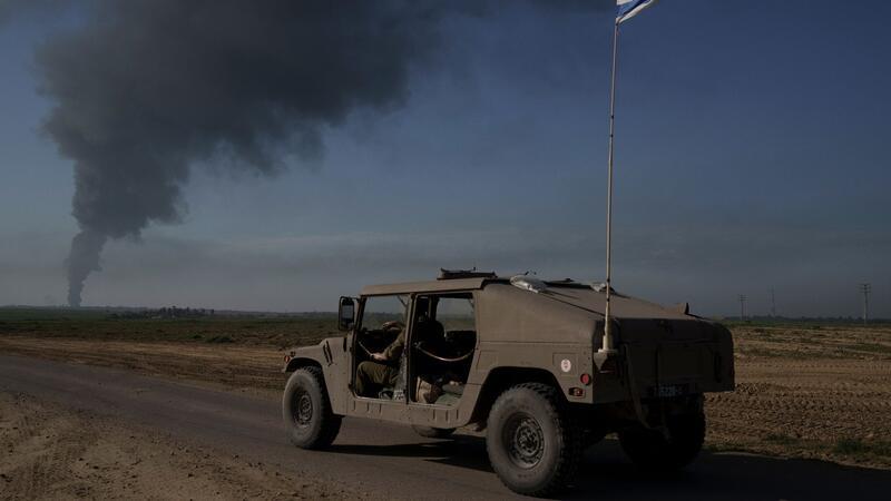 Mehrere israelische Soldaten bei Vorfall getötet Israelische Soldaten in der Nähe der Grenze zwischen Israel und Gaza, während im Gazastreifen Rauch in den Himmel steigt.