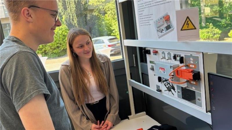 Geraten E-Autos leichter in Brand? Fachmann aus Buxtehude antwortet Jaimee Schultz und Celin Böttcher, beide Auszubildende zum KfZ-Mechatroniker im zweiten Lehrjahr, lernen am Kfz-Hochvolt-Sicherheitstrainer den sicheren Umgang mit Hochvoltsystemen im E-Auto.