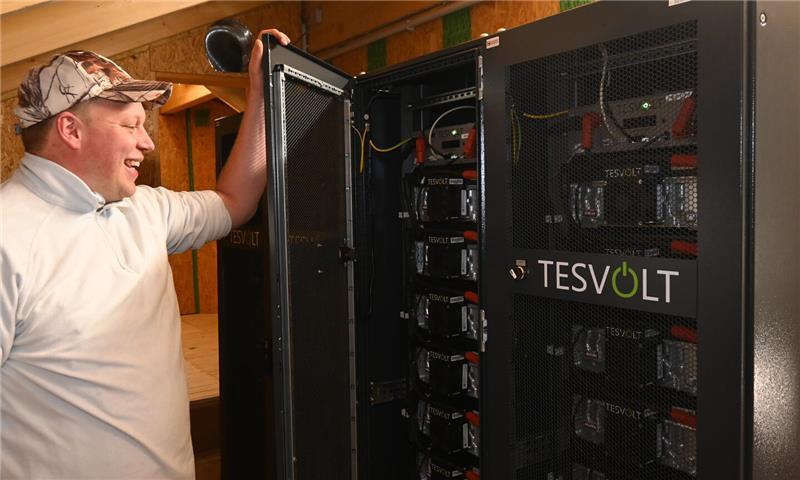 Jan-Eric Quast öffnet den Solarstromspeicher der Altländer Mettwurst- und Schinkenräucherei in Neuenfelde.