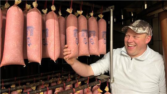 Jan-Eric Quast von der Altländer Mettwurst- und Schinkenräucherei in Neuenfelde holt neue Ware aus der Räucherei.