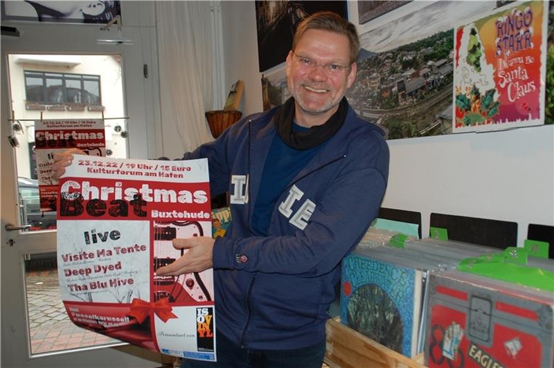 Jan Iso Jürgens zeigt in seinem Schallplattengeschäft das Plakat zum Christmas Beat. Foto: Laudien