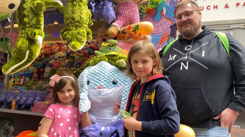 Jan Reisenberg und seine Kinder Tim und Lea versuchen ihr Glück an der Losbude und hoffen auf den blauen Plüschhasen in Gymnastikballgröße