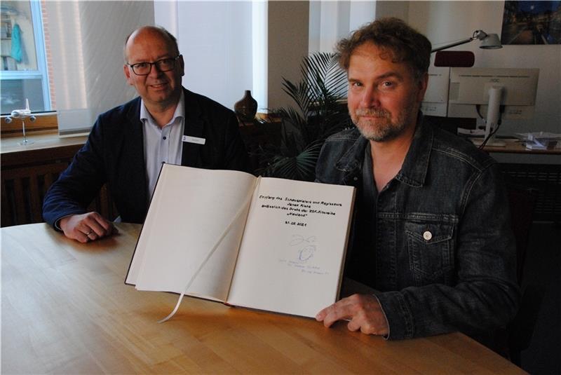 Janek Rieke (rechts) hat sich bei Bürgermeister Sönke Hartlef ins Goldene Buch der Stadt Stade eingetragen. Foto: Stief