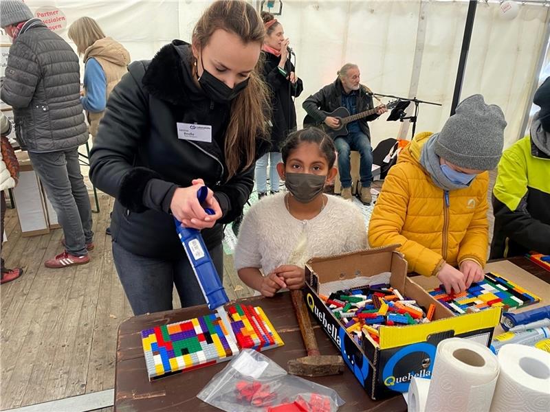 Janine Beuße (Lebenshilfe) verklebt das Bauwerk von Japneet Kaur .