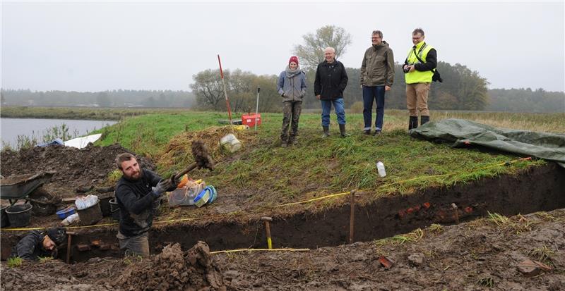 Janna Kordowski und Dr. Donat Wehner (Zweiter von rechts) von der Uni Kiel leiten die Ausgrabungen und informieren den Kreisarchäologen Daniel Nösler (rechts) und Deichgraf Horst Wartner. Foto Schult