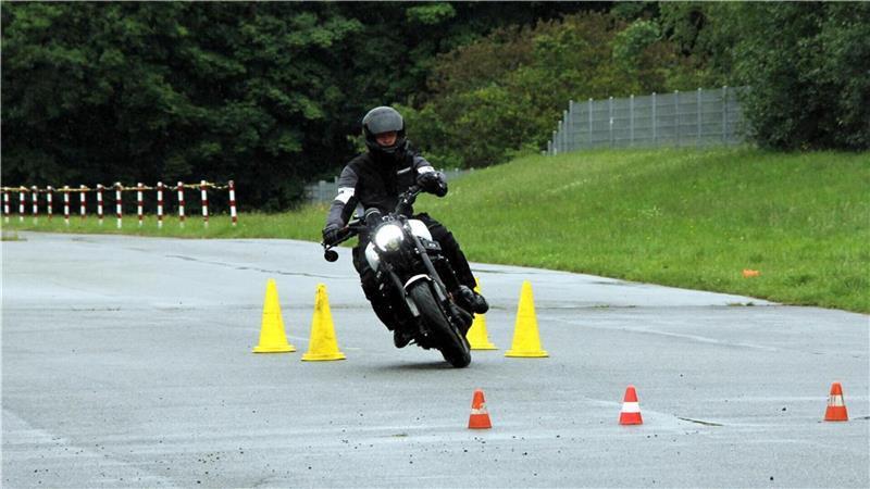 Ein Motorradfahrer fährt um Pylone.