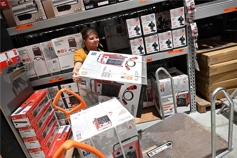 Jessica Bendorf, Mitarbeiterin bei Hornbach, räumt einen Heizlüfter aus einem Regal auf einen Wagen im Hornbach Baumarkt Fröttmaning. Die Angst vor Gas-Engpässen im kommenden Winter sorgt mitten im Sommer für einen Nachfrageboom bei Heizlüftern, Konvektorheizungen und Ölradiatoren. Foto: Felix Hörhager/dpa