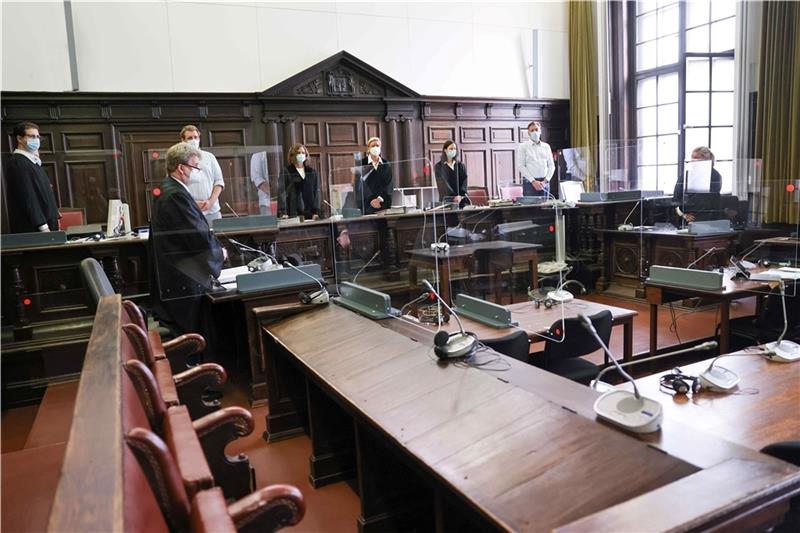 Dauerhaft in Psychiatrie: Junger Mann ermordete Freundin und Mutter Jessica Koerner (5.v.l), Vorsitzende Richterin am Landgericht, Peter Jacobi (2.v.l), Anwalt des Beschuldigten, und weitere Prozessbeteiligte stehen zu Beginn des ersten Prozesstages im Sitzungssaal. Foto: Charisius/dpa