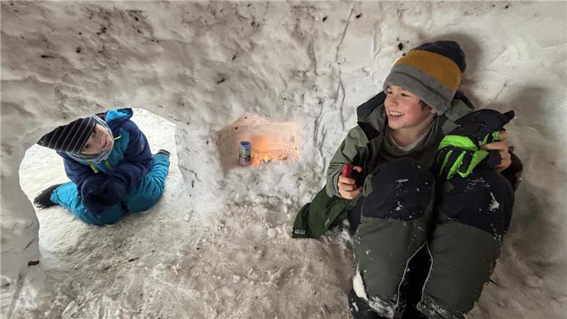 Johann (links) und Erik haben es sich im Iglu mit Kerzen gemütlich gemacht.