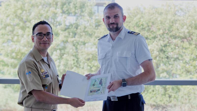 John Corredor (l.) erhält seine Urkunde von Kapitänleutnant Sven Andre in der Marineoperationsschule in Bremerhaven.