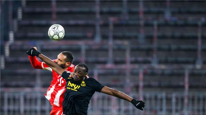 Jonathan Tah vom FC Bayern München vor der leeren Südkurve im Kopfballduell gegen Promise David von Union St. Gilloise.