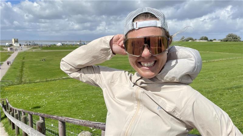 Sie umrundet Deutschland im Laufschritt: Running Girl Joyce Joyce Hübner auf dem Tossenser Deich. Der Wind weht so stark, dass sie ihre Mütze festhalten muss. Foto: Glückselig