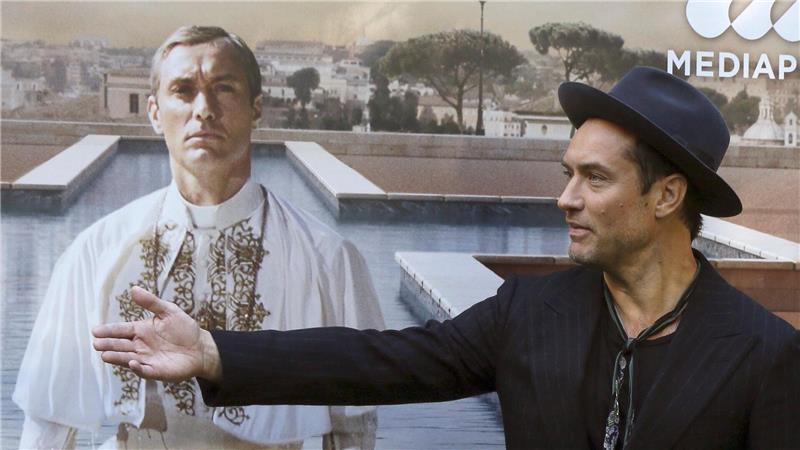 Papst aus den USA? In Serie mit Jude Law durchexerziert Jude Law vor einem Plakat mit sich als Papst Pius XIII. in der Serie „The Young Pope“. (Archivbild)