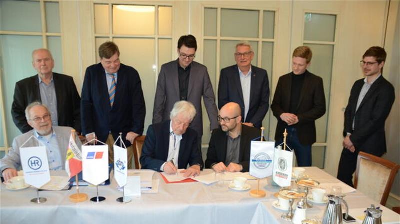 Jürgen Grzeskowiak und Marcus Rönner (rechts) unterzeichnen die Absichtserklärung zur Zusammenarbeit. Links sitzend: Ingenieur Klaus-Peter Lasse. Stehend von links: Heinrich Rönner, Enak Ferlemann, Christoph Frauenpreiß, Carsten Panke, Paul Pultke und Max von Vopelius.