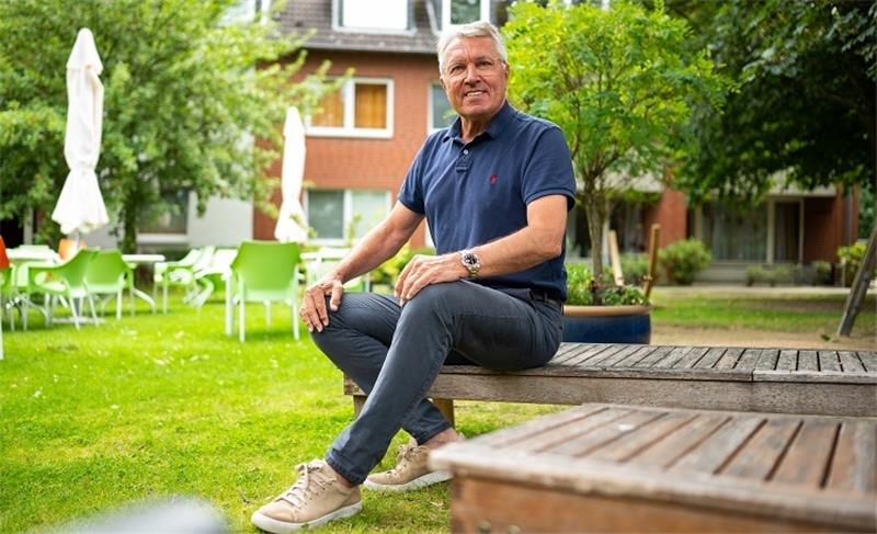 Jürgen Rynio sitzt im Garten von seinem Heim für geistig und mehrfach behinderte Menschen. Der langjährige Torwart Jürgen Rynio hatte irgendwann genug vom Fußball. Foto: Philipp Schulze/dpa