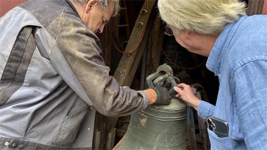 Jürgen Schwarck von der Hamburger Firma Iversen-Dimier und Pastor Uwe Junge nehmen die demontierte Glocke in Augenschein.
