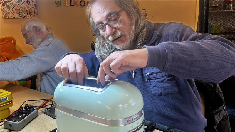 Jürgen Werner untersucht im Repaircafé einen Toaster.