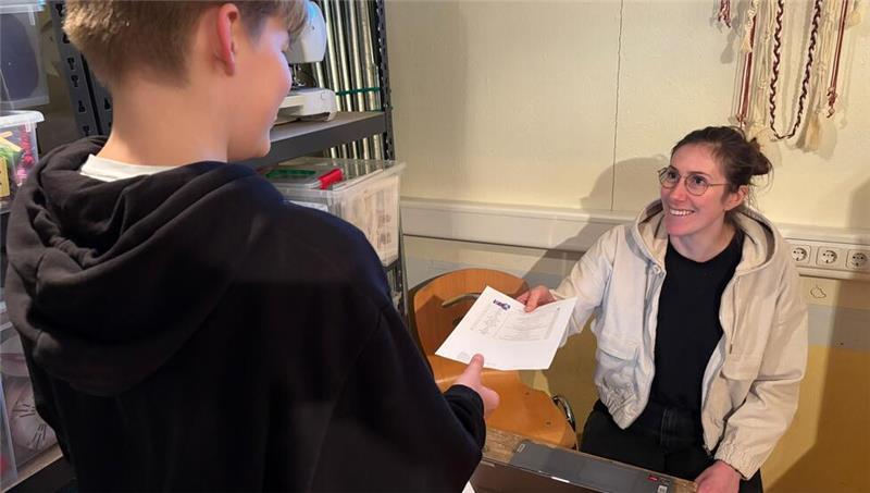 Jugendpflegerin Luisa Hinz gibt nach der Anmeldung den Stimmzettel für Max aus.