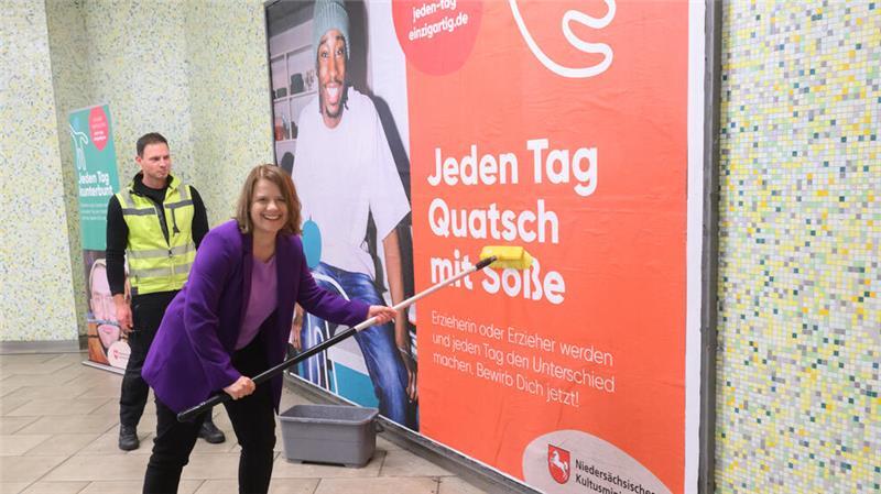 „Quatsch mit Soße“: Das steckt hinter dieser Werbekampagne Julia Willie Hamburg (Grüne), Kultusministerin in Niedersachsen, klebt ein Werbeplakat auf eine Wand.