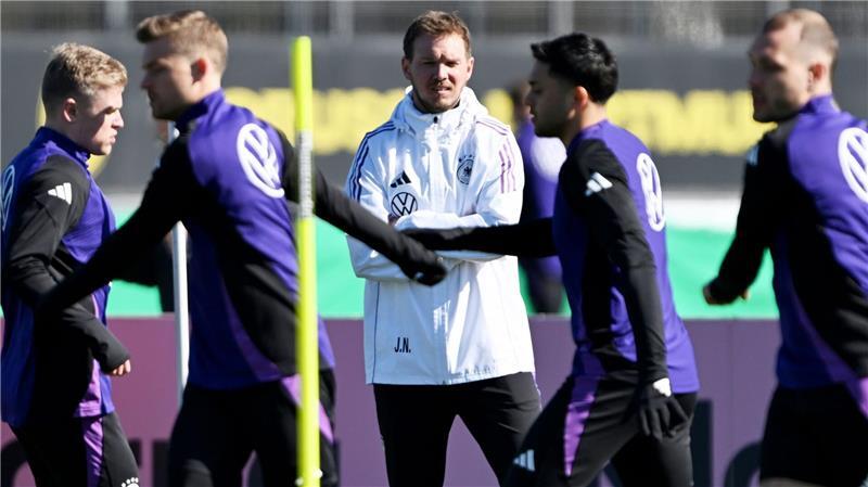 Erstes Training mit allen Spielern und einem Torwart-Duell Julian Nagelsmann (M) beobachtet das Aufwärmen seiner Spieler.