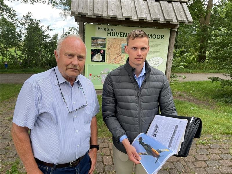 Julien Jendral (rechts) und Fritz Metscher vom „Initiativkreis Huvenhoopsflieger“ mit dem Foto einer Messerschmitt Bf 109 („Me 109“). Ein Jagdbomber dieses Typs wird im Huvenhoopssee vermutet.