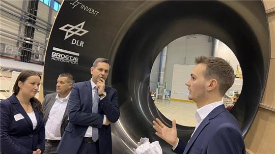 Julius Biermann (rechts) zeigt Wirtschaftsminister Olaf Lies (SPD) und der Landtagsabgeordneten Corinna Lange (SPD) einen Prototypen für den Wasserstofftank. Im Hintergrund Airbus-Chef André Walter.