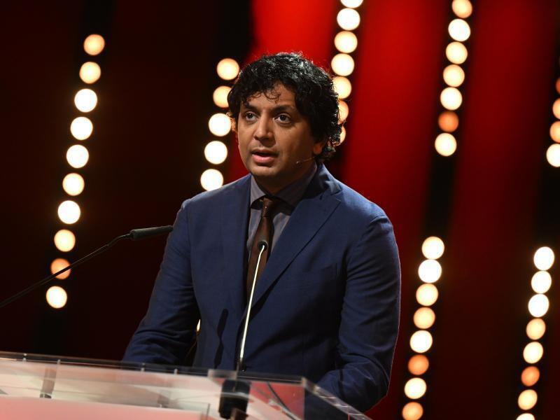 Jurypräsident M. Night Shyamalan verkündet den Gewinner des Goldenen Bären. Foto: Monika Skolimowska/dpa-Zentralbild/dpa