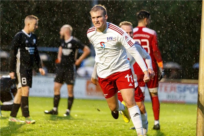 Justin Allers setzt nach seinem Kopfballtor zum Jubellauf an, während die Hedendorfer bedröppelt im Regen stehen. Foto: Struwe