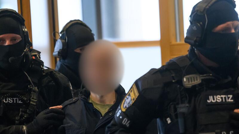 Nach Geiselnahme im Gefängnis: Urteil gegen Halle-Attentäter Justitzbeamte führen den Angeklagten in den Gerichtssaal in Magdeburg.