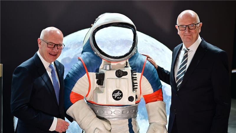 Kai Wegner (l, CDU), Regierender Bürgermeister von Berlin, und Dietmar Woidke (SPD), Ministerpräsident von Brandenburg, stehen neben einem Modell eines Weltraumanzuges.