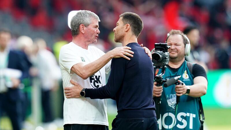 Kaiserslauterns Trainer Friedhelm Funkel (l) und Bayer-Coach Xabi Alonso begrüßen sich vor der Partie.