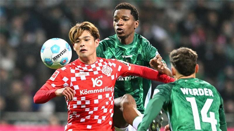 Turbulentes Spiel in Bremen: Beide Trainer jetzt gesperrt Kaishu Sano (l) von Mainz 05 wird von den Bremern Skelly Alvero (M) und Senne Lynen bedrängt.