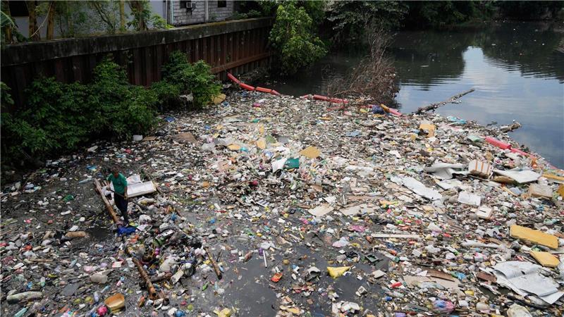 Bilder des Tages Kampf dem Müll: Ein Arbeiter sammelt Plastikmüll und andere Abfälle am San Juan-Fluss auf den Philippinen ein.