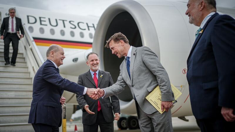 Scholz redet Netanjahu bei Israel-Besuch ins Gewissen Kanzler Scholz wird auf dem Flughafen von Tel Aviv vom deutschen BOtschafter Steffen Seibert begrüßt. Rechts der israelische Botschafter in Deutschland, Ron Prosor.