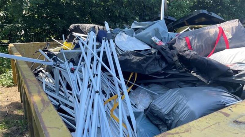 Unwetter: Hunderte Kinder von Zeltplatz am Strand in Sicherheit gebracht Kaputte Zelte und andere Ausrüstungsüberreste werden nach dem heftigen Unwetter in Containern entsorgt.