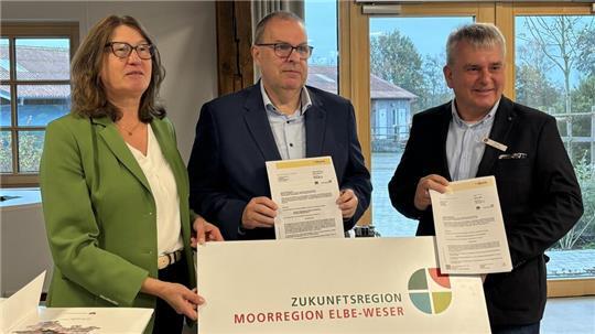 Karin Beckmann überreicht die Förderbescheide für den Landkreis Cuxhaven an Landrat Thorsten Krüger (Mitte) und für den Landkreis Stade an Kai-Ulrich Baak, Leiter Fachbereich Wirtschaft, Verkehr, Bildung, Landkreis Stade.