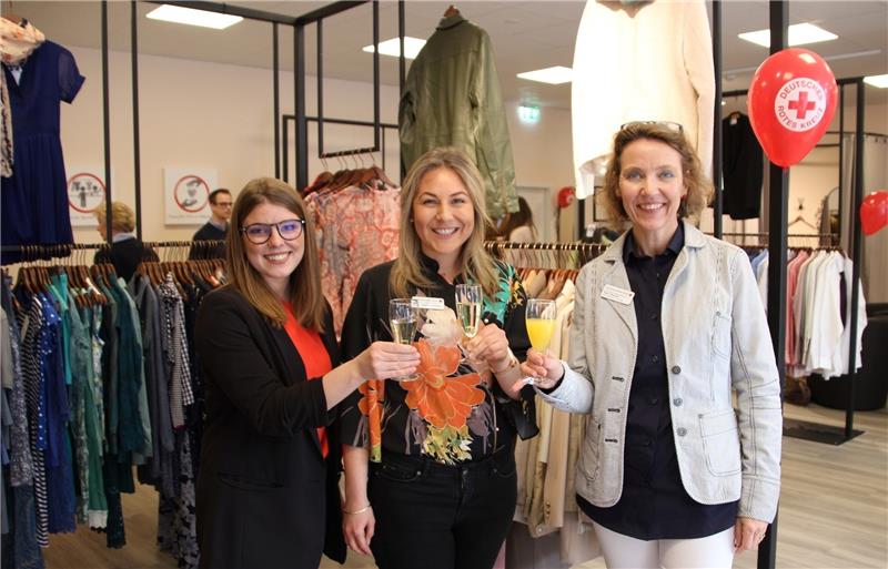 Karin Bischoff (rechts) und Rosa Schlottau (Mitte) vom Harburger Roten Kreuz freuten sich mit Moderatorin Luca Sophie Büttner, Gästen und Kunden über die Eröffnung des DRK-Shops „Schwester Henny“.