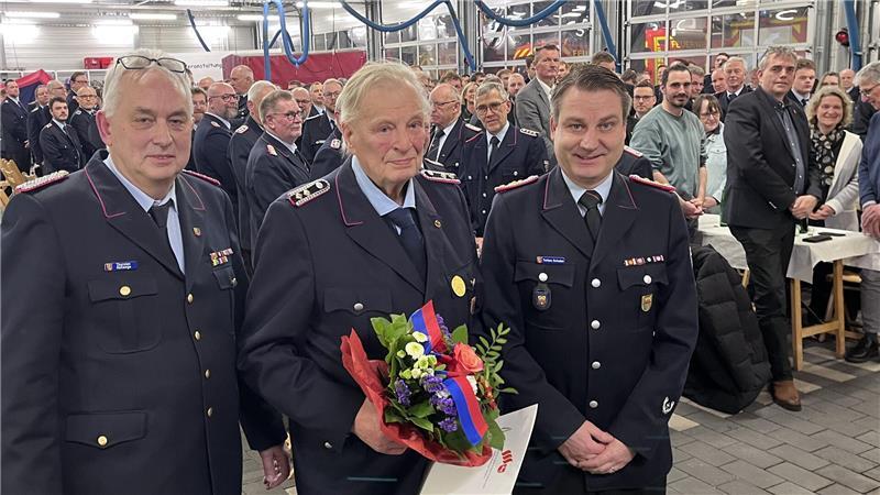 Karl-Heinz Meier (Mitte) aus Bliedersdorf ist seit 70 Jahren in der Feuerwehr: Der stellvertretende Kreisbrandmeister Thorsten Hellwege und Gemeindebrandmeister Torben Schulze (rechts) ehrten ihn bei der Jahreshauptversammlung. Hinten rechts hat sich Bliedersdorfs Bürgermeister Tobias Terne (CDU) erhoben.