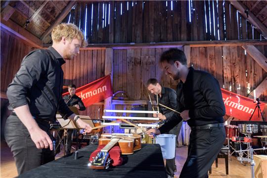 Karl Johann Lattikas und Tanel-Eiko Novikov bearbeiten eine Gitarre mit Schlagstöcken. Dahinter: Tiit Joamets und Lauri Metsvahi.
